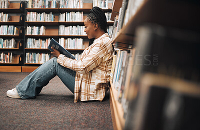 Buy stock photo Bookshelf, library book and black woman reading, learning education and search knowledge at a university, college or campus. African student on floor reading book studying for exam or English project