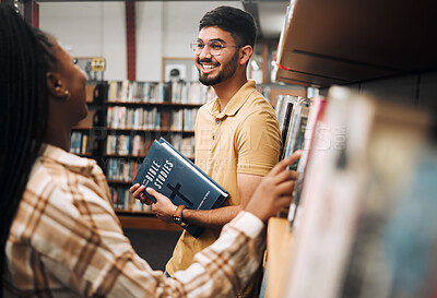 Buy stock photo Talking students, bonding and library bookshelf on school, college and university campus for education, learning and religion studying. Smile, happy man and black woman friends with textbook research