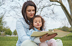 Nature, mother and child reading book in park, story time in park or garden on summer weekend. Storytelling, books and love, mom teaching girl to read sitting on grass in backyard and relax together.