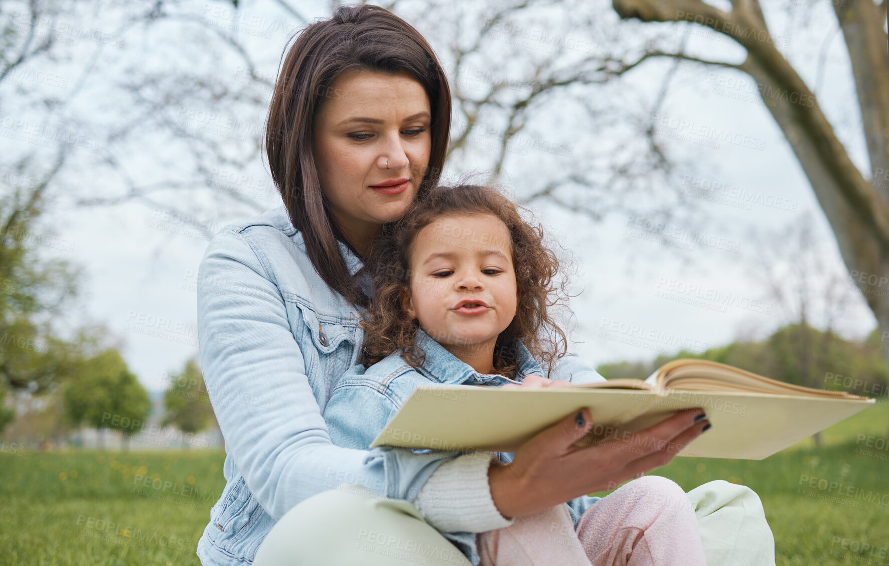 Buy stock photo Nature, mother and child reading book in park, story time in park or garden on summer weekend. Storytelling, books and love, mom teaching girl to read sitting on grass in backyard and relax together.