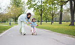 Bike, learning and mother teaching girl on road outdoors, having fun and bonding. Care, education and happy mom showing child how to ride bicycle on street, smiling and enjoying quality time together