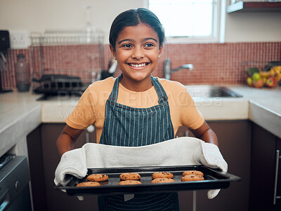 Buy stock photo Baking, cookies and children with an indian girl cooking baked goods in the kitchen of her home alone. Food, kids and apron with a female child learning how to bake in her house in the morning