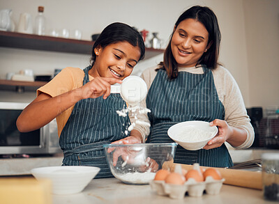 Buy stock photo Baking, family and children with a mother and daughter learning about cooking in a kitchen of their home together. Food, bake and kids with a girl and indian woman teaching her kid about baked goods