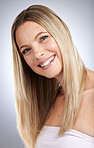 Portrait, hair and beauty with a model woman in studio on a gray background to promote keratin treatment. Face, haircare and smile with a happy young female inside for natural hair care or growth
