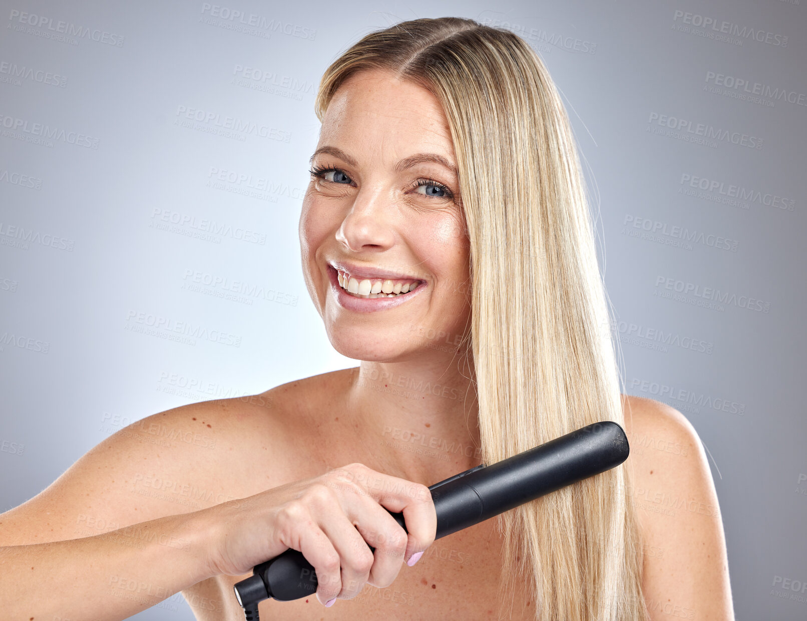 Buy stock photo Hair care, salon styling and woman with straightener, marketing product and happy with ceramic ironing on grey studio background. Luxury, beauty salon and face portrait of a model straightening hair