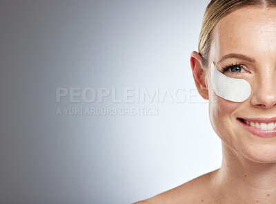 Buy stock photo Face, eye mask and mockup with a model woman in studio on gray background for beauty advertising or marketing. Portrait, anti aging and treatment with a young female posing to promote a skin product