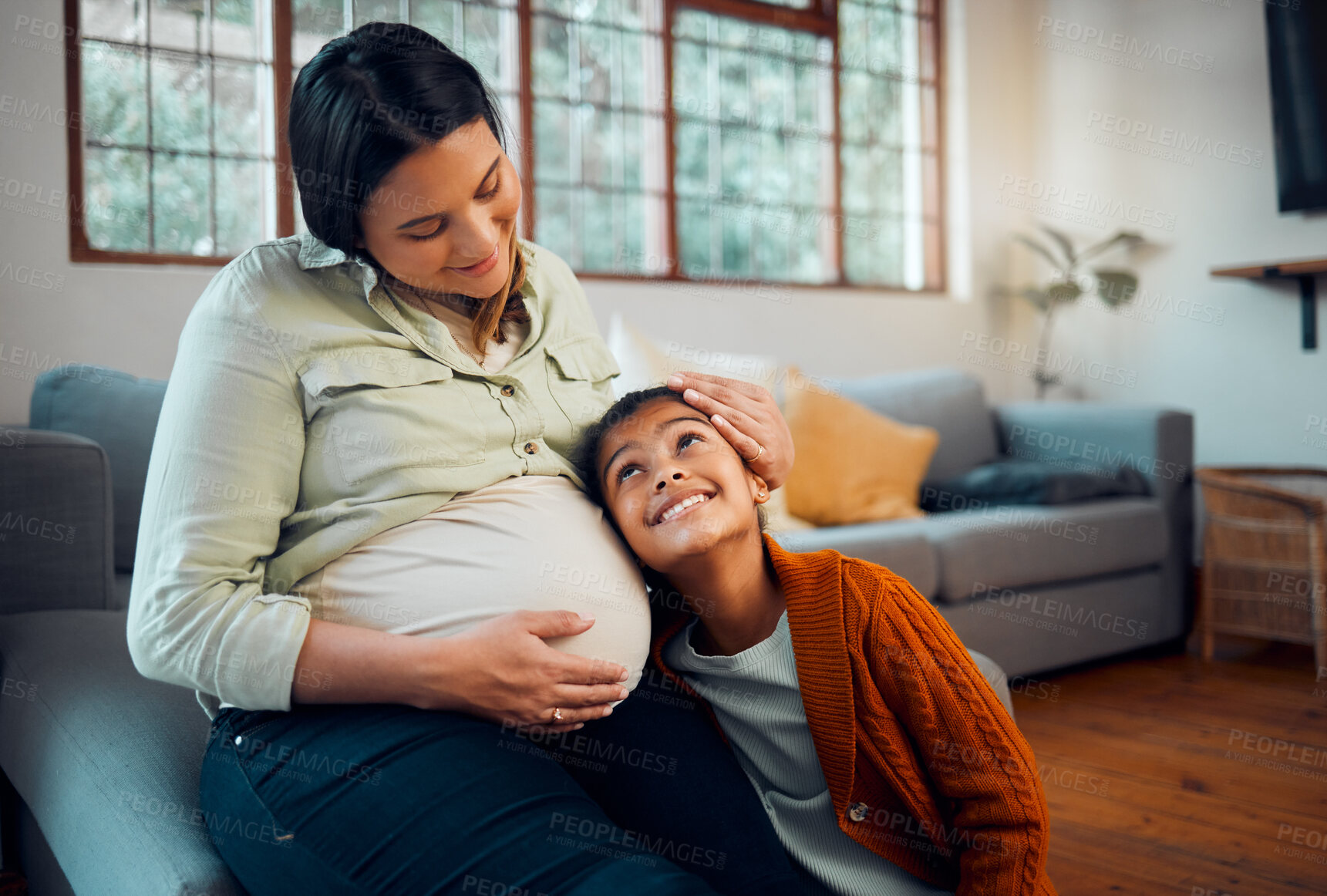 Buy stock photo Pregnancy, family and girl with pregnant mother listening to newborn baby with love, affection and bonding. Family home, maternity and mom on sofa with child with ear to pregnant belly in living room