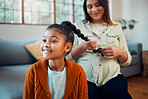 Mom, girl and hair care in living room for bonding, love and care by sofa with happiness in home. Hair, mother and daughter for hairdresser, pony tail or helping hand with grooming for kid in Atlanta
