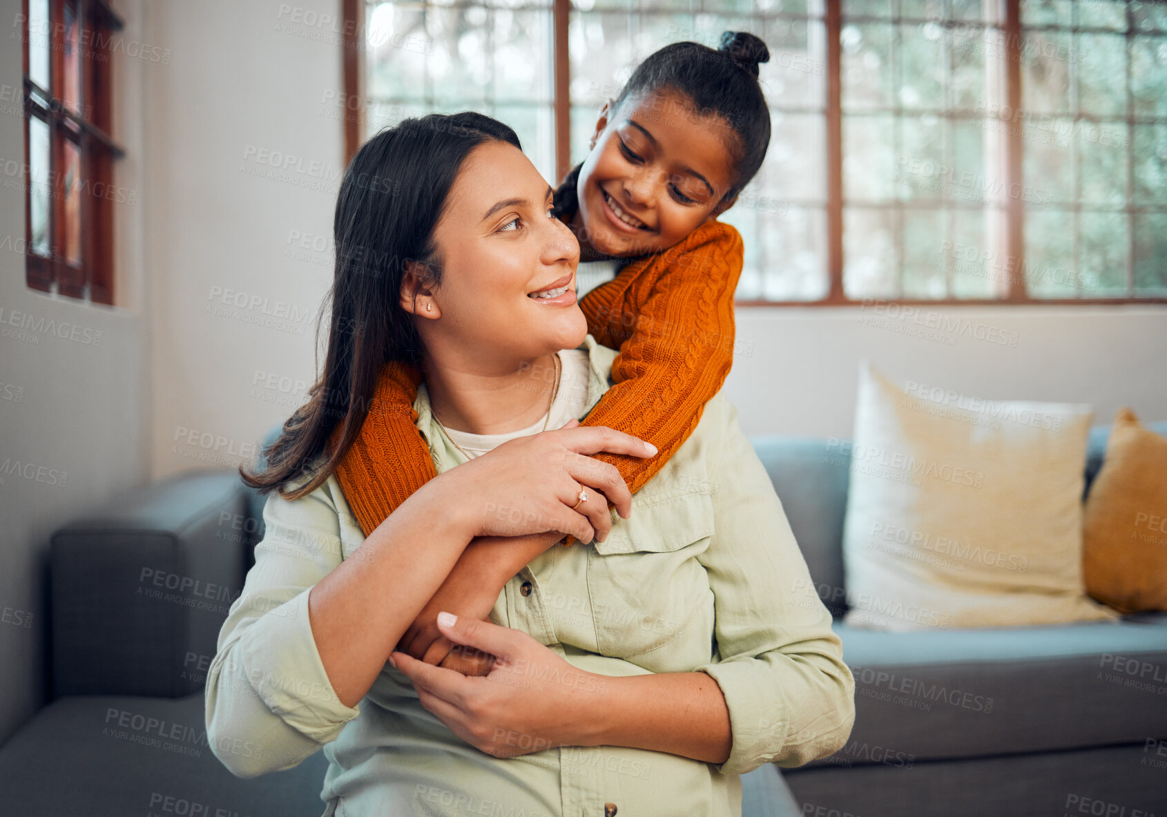 Buy stock photo Mom, girl and hug by sofa in living room, family home and happy together for love, bonding and care. Happiness, mother and daughter with embrace, trust and smile as happy family at house in Mexico