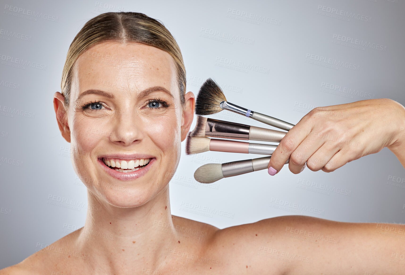 Buy stock photo Woman, makeup brushes and portrait smile for cosmetics, beauty or facial treatment against a studio background. Happy face of female model smiling in skincare holding makeup tools for self care