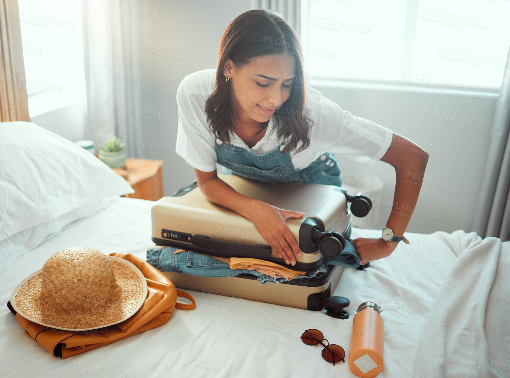 Buy stock photo Woman, overloaded suitcase and luggage bag in bedroom for travel, vacation and international journey, holiday and trip. Female tourist struggle to close baggage full of clothing, packing and problem