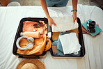 Travel packing, above and hands of a woman with clothes, holiday luggage and prepare for international summer. Suitcase, ready and person traveling with a suitcase, vacation clothing and hotel bag
