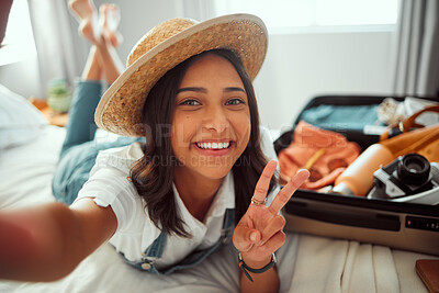 Buy stock photo Portrait, travel and selfie by woman on bed with luggage, smile and happy before leaving for vacation. Face, girl and peaceful hand sign by travelling influencer pose for blog, photo and social media