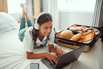 Buy stock photo Computer travel and woman packing for a vacation with headphones typing a holiday blog. Adventure, planning and female happy on a hotel room bed with a luggage, suitcase and bag ready for a journey