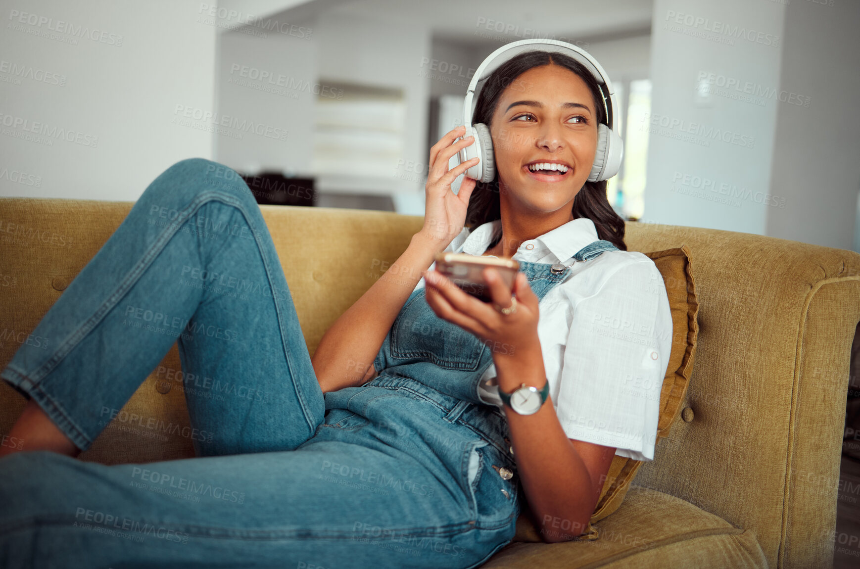 Buy stock photo Young girl, headphones and music with smartphone, relax at home with technology and listening to podcast, radio and audio streaming. Online, social network and happy on sofa with sound and wellness.