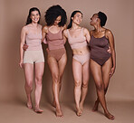 Beauty, skincare and diversity of women with hug and smile for health, wellness and confidence. Body care, natural and cosmetic model group in underwear for inclusive campaign at brown studio.

