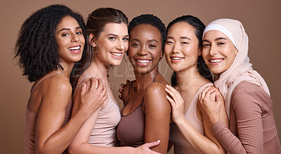 Buy stock photo Skincare, diversity and women hug portrait for inclusivity, happiness and healthy skin texture. Interracial beauty and model group with woman in hijab smile for cosmetic campaign in brown studio
