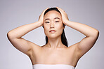 Asian, beauty and skincare portrait of woman with hair removal, body care or dermatology cosmetic treatment for armpit. Health, natural and confident model aesthetic pose in gray studio.