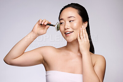 Buy stock photo Beauty, face massage and skin with woman and cosmetic tools, facial treatment with wellness, skincare and healthy glow. Roller, body care and natural cosmetics marketing against studio background.
