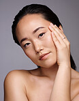 Skincare, woman and beauty studio for portrait, wellness and cosmetic health by grey backdrop. Model, asian and cosmetics girl with radiant skin, smooth glow and makeup aesthetic by studio background