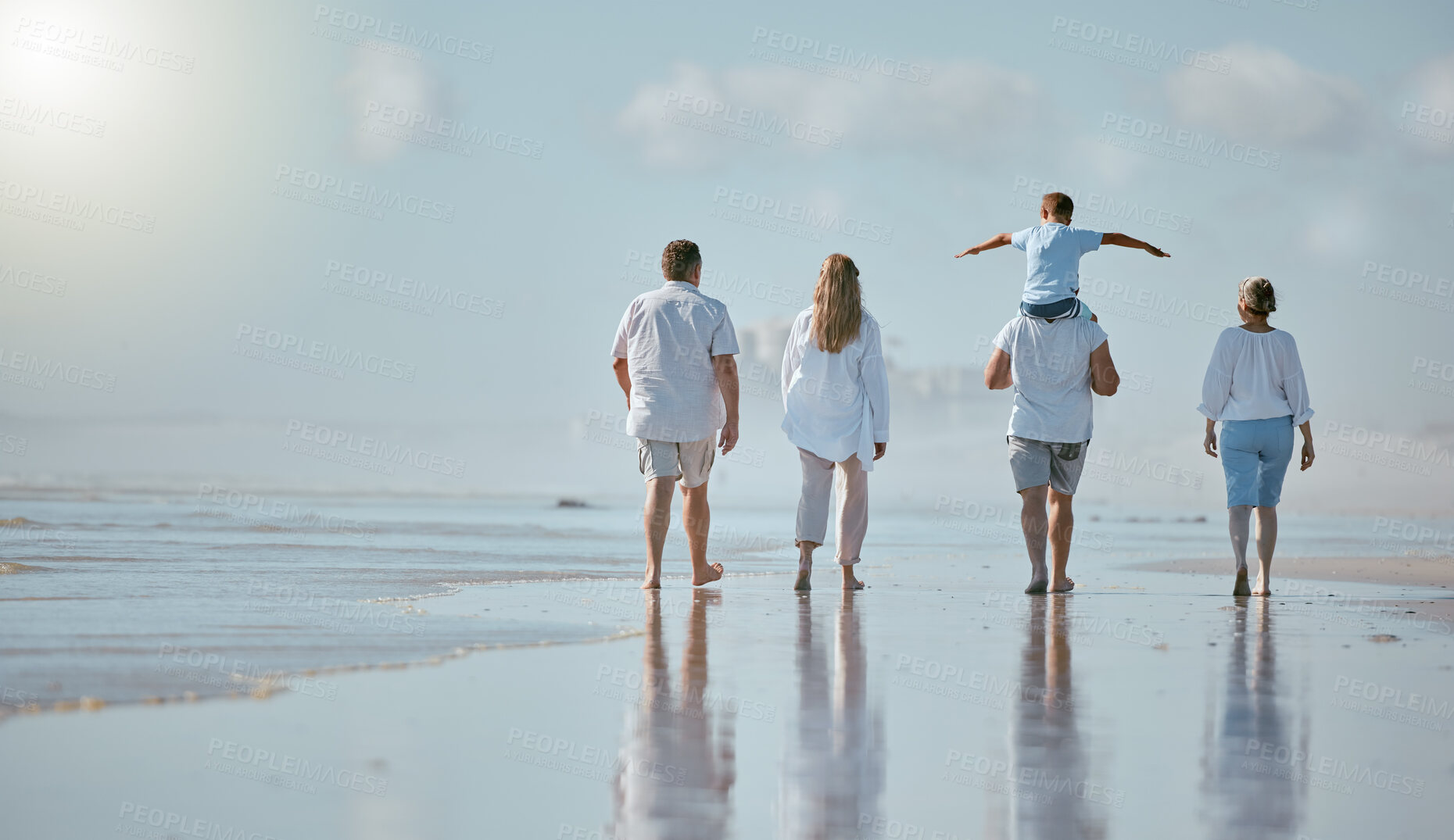 Buy stock photo Family, beach and men with women and child from back with blue sky on outdoor summer vacation. Happy family mother, father and kid with piggy back fun walking in sun and quality time together at sea.