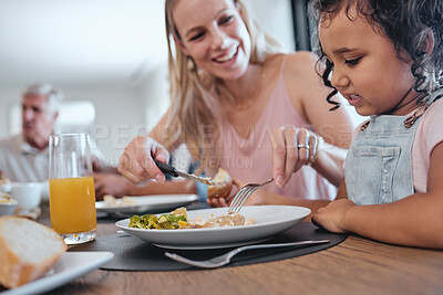 Buy stock photo Family, mother and cutting food for girl while having lunch at dinner table in home. Love, foster care and happy mom helping child with eating, smiling and enjoying a delicious meal together in house