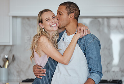 Buy stock photo Love, interracial and couple kiss in kitchen, happiness and loving together for relationship. Romance, man and woman with embrace, kissing and celebrate for anniversary, cooking and relax with hug.