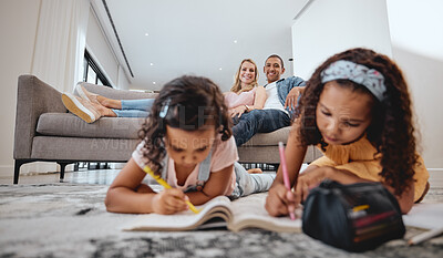 Buy stock photo Wellness, relax and family with children drawing in coloring book in living room with happy parents. Interracial, mother and father on home sofa watching young kids draw and bond together.

