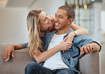 Buy stock photo Love, happy and smile with a diversity couple hugging on a sofa in the living room of their home together. Support, romance and affection with a man and woman sharing an intimate moment in a house