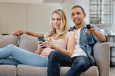 Buy stock photo Curious, jealous and couple watching tv with a phone, social media and movie on living room sofa. Relax, jealousy and man reading communication on mobile app of a woman while on the couch for a film