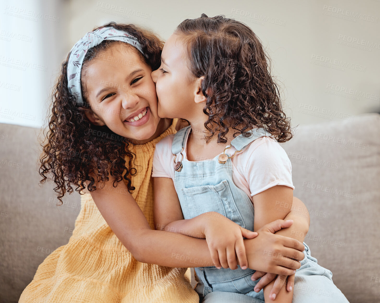 Buy stock photo Family, kids hug and kiss on sofa in living room, smiling or bonding. Love, care and portrait of sisters, girls or siblings embrace on couch in lounge, kissing cheek or enjoying quality time together