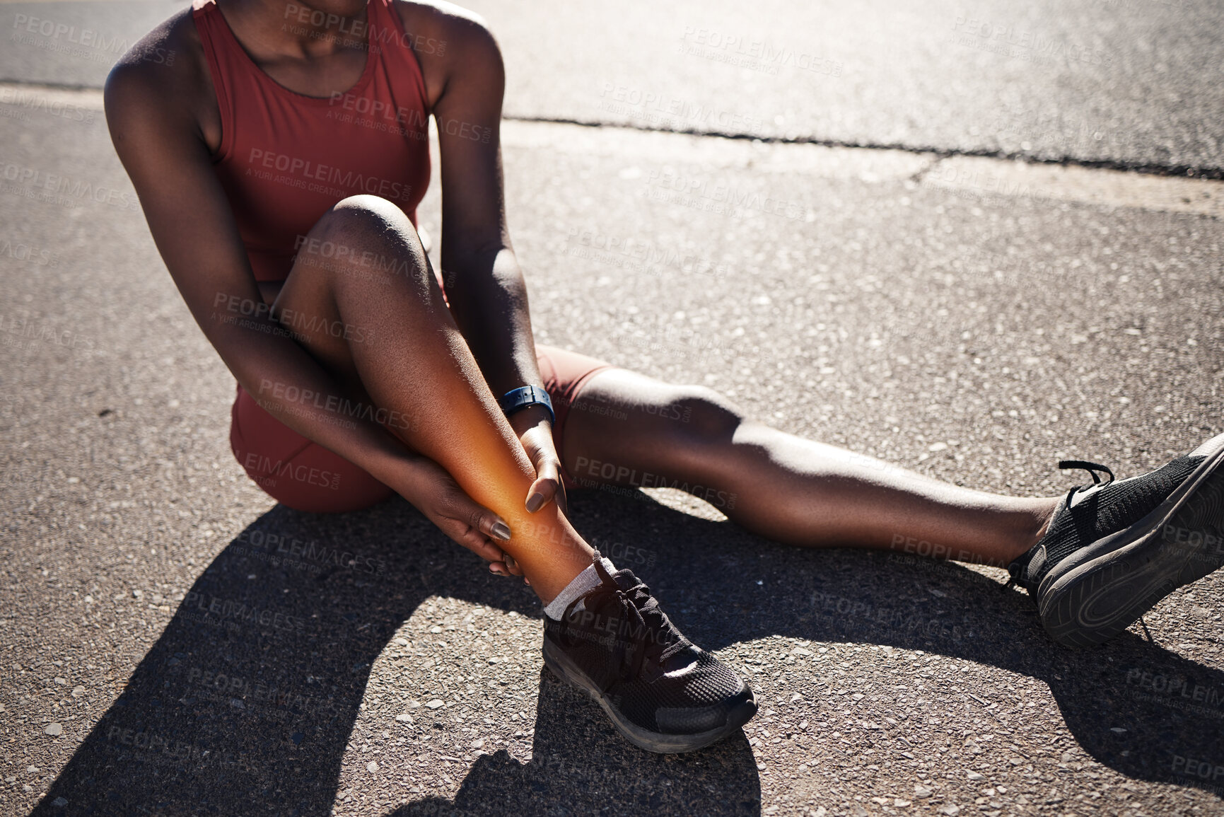 Buy stock photo Leg, injury and pain with a sports black woman holding her ankle outdoor during a fitness workout from above. Ankle, sprain or exercise with a female runner or athlete suffering from an injured joint