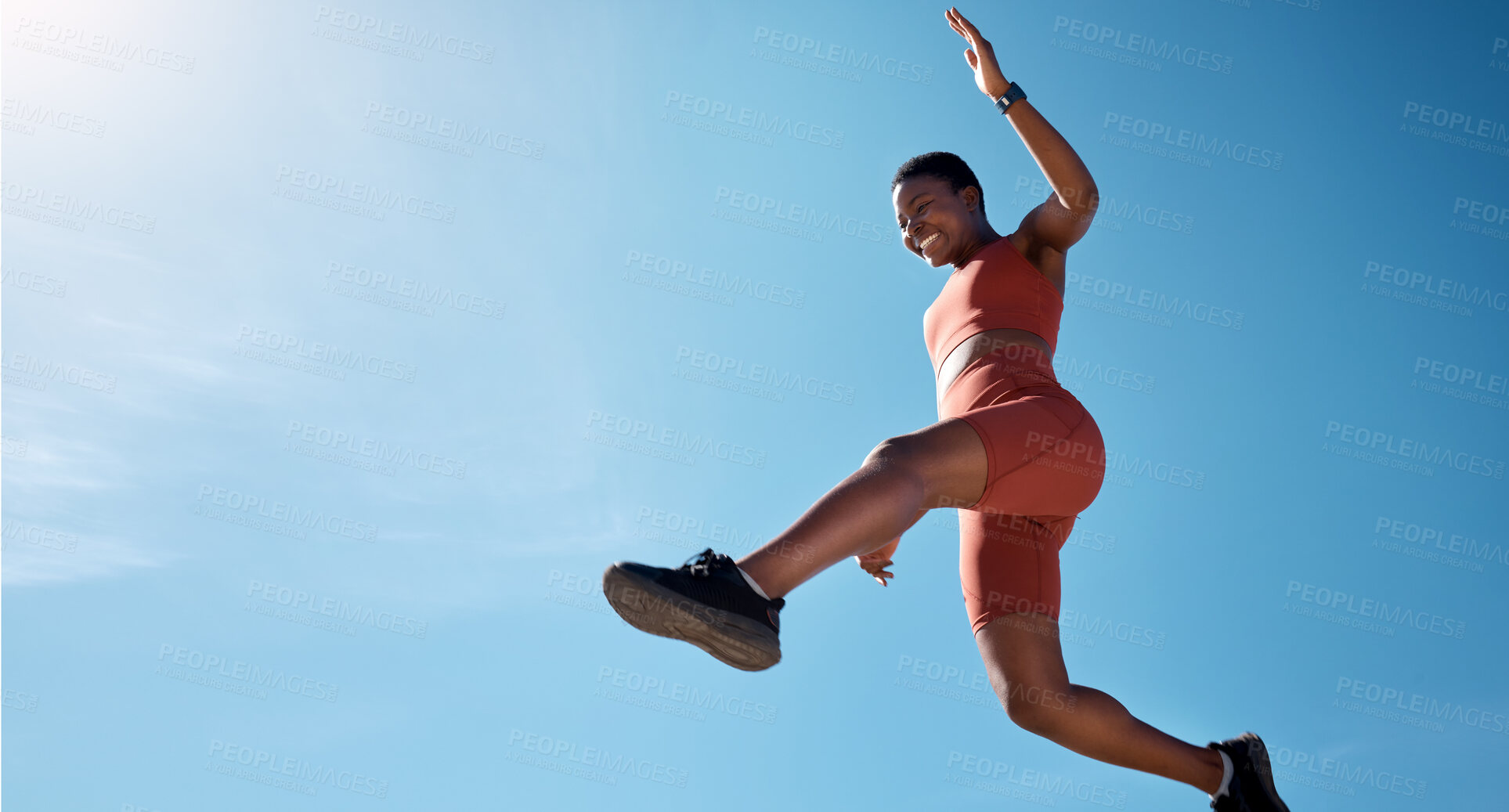 Buy stock photo Sports, fitness and black woman jumping with blue sky background from below. Running, exercise and jump, woman training for health goals, motivation and wellness with happy smile and mockup in summer