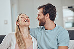 Couple, laughing and home of a woman and man in a living room with love, happiness and care. House, relax and funny joke of a happy couple on a house sofa smile about bonding and marriage together