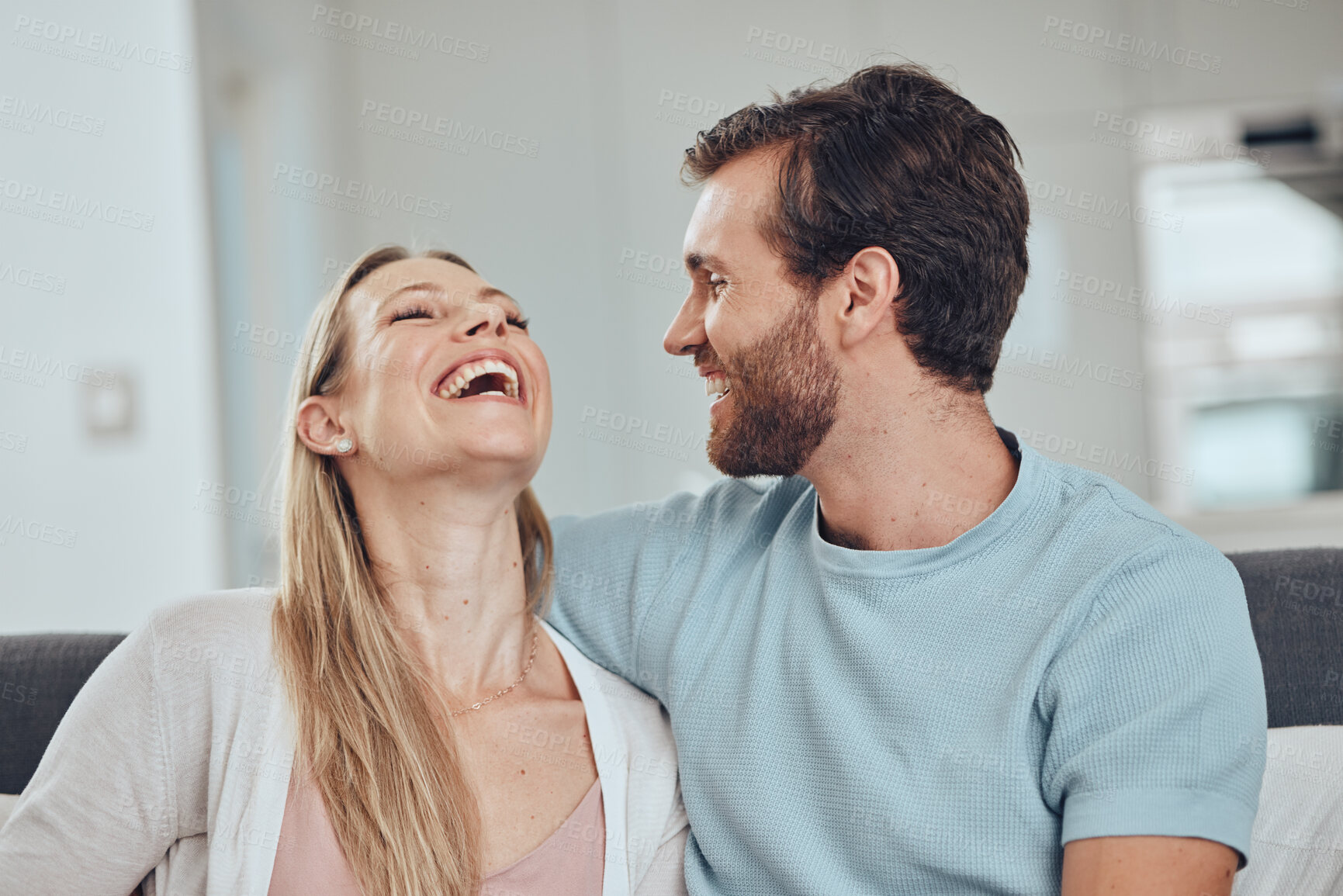 Buy stock photo Couple, laughing and home of a woman and man in a living room with love, happiness and care. House, relax and funny joke of a happy couple on a house sofa smile about bonding and marriage together