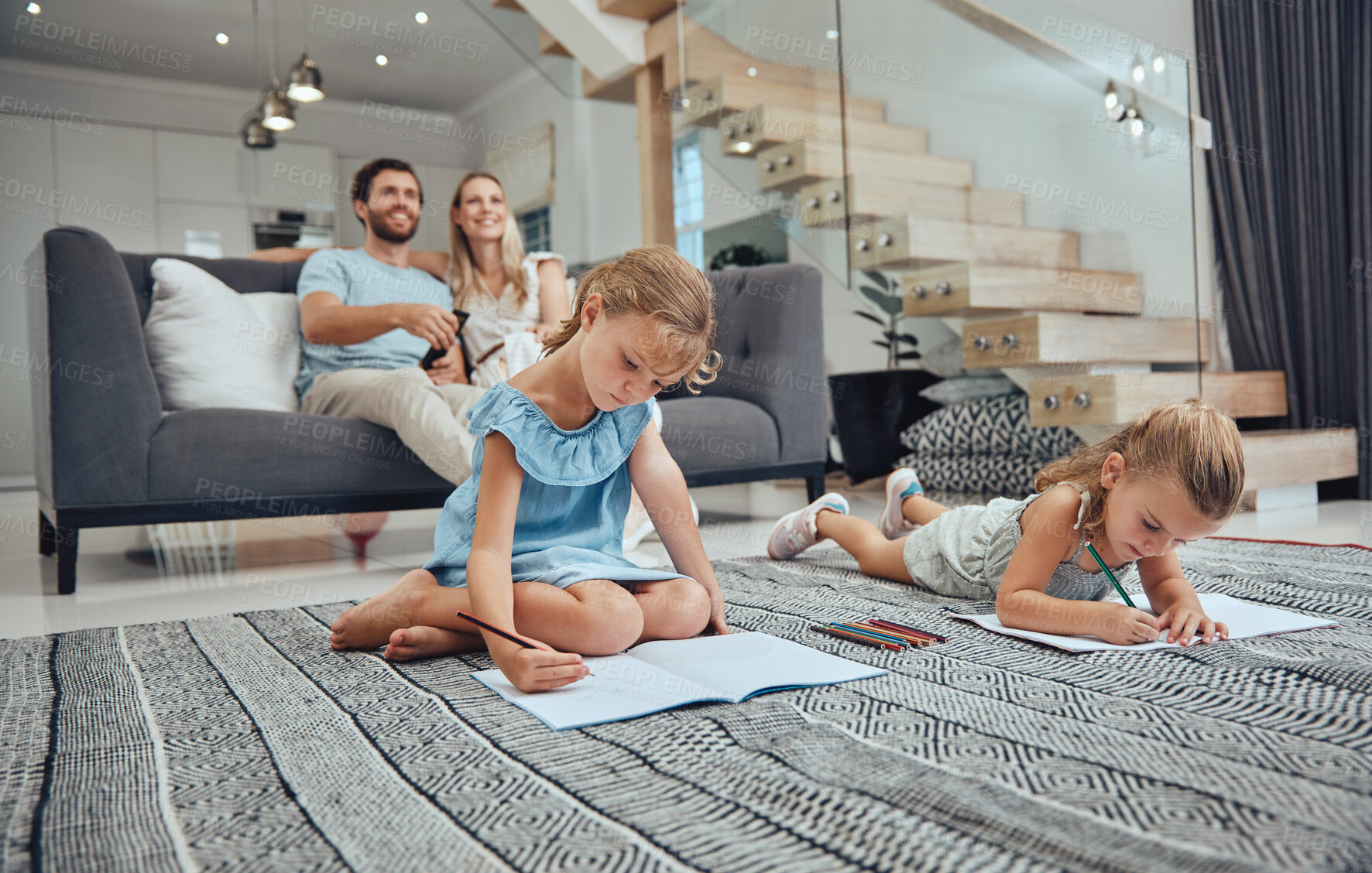 Buy stock photo Learning, family and kids drawing in living room with parents in home. Art education, homework and creative girls sketching in books, studying on floor with mother and father sitting on sofa in house