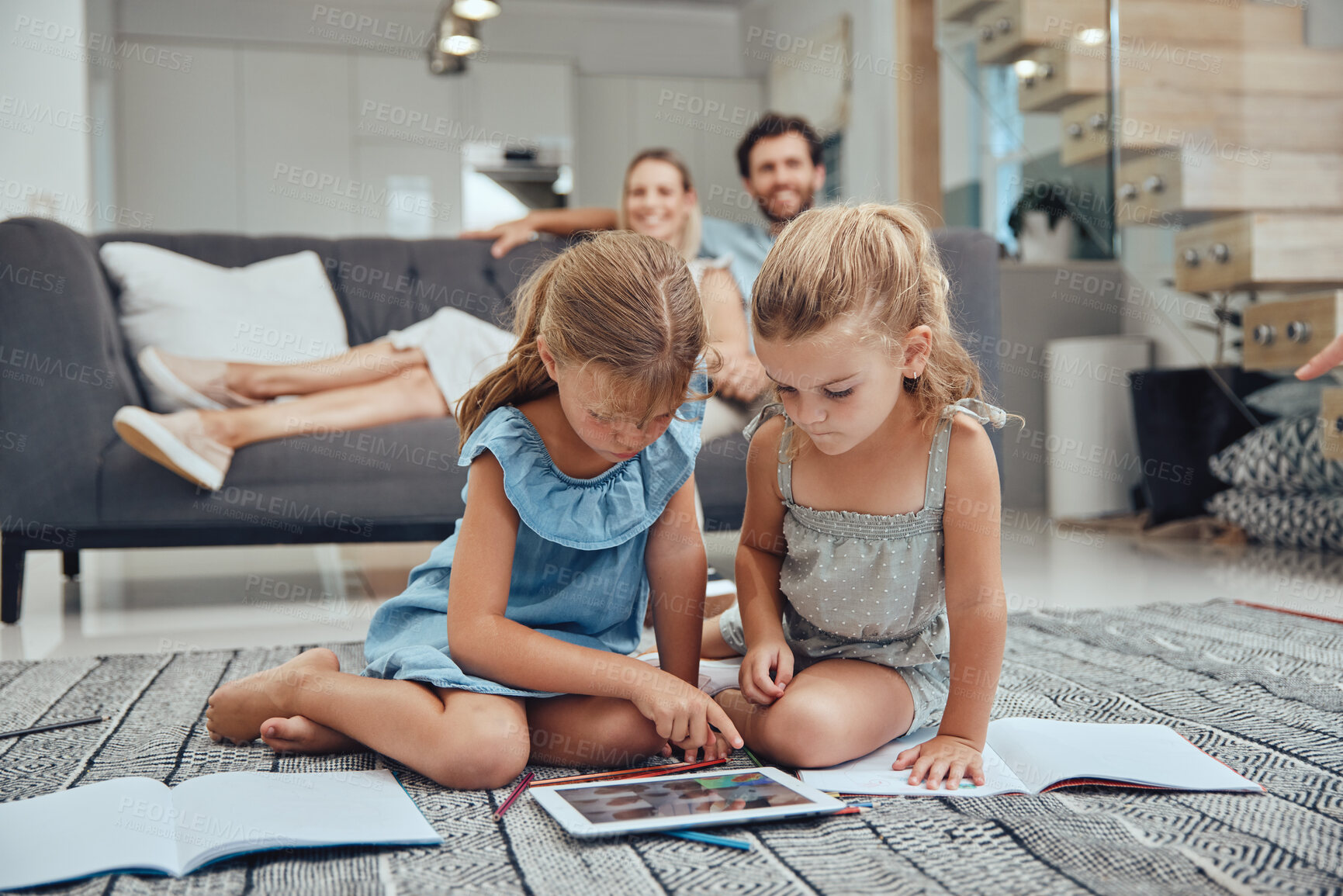 Buy stock photo Living room, parents relaxing and children doing elearning on tablet in books on the floor in their home. Mother, father and girl kids sitting in lounge together for homeschool learning and studying.