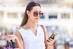 Woman, shopping bag and phone in city street for social media, searching store location or reading retail discounts online. Fashion shopping, 5g mobile communication and stylist or customer promo