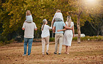 Big family, park and nature walking of mother, grandparent and children with love and care. Happy family, outdoor and autumn field walk on vacation with grandmother, dad and girl back together