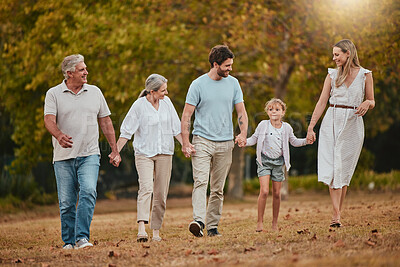 Buy stock photo Family, walking and holding hands outdoor with mother, dad and girl happy with grandparents. Happy family, love and parent care in nature with a child in a grass field park in autumn on holiday