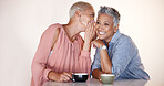 Senior women, bonding or whispering secrets in coffee shop, restaurant or cafe and funny gossip, news or story. Smile, happy or retirement elderly friends whispering in ear or sharing in rumor spread