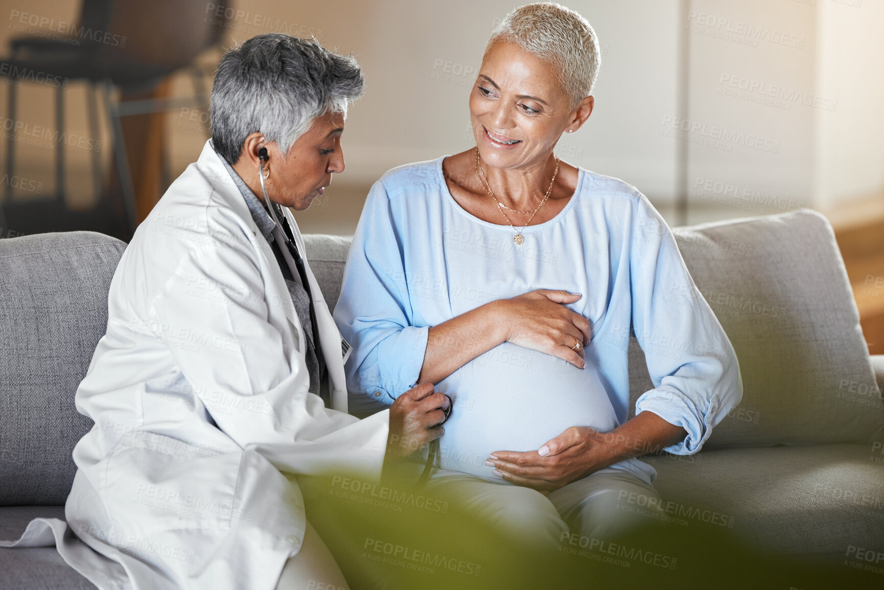 Buy stock photo Healthcare, ivf consulting and pregnant woman with doctor on sofa for examination, checkup and baby health during home visit. Senior woman, pregnancy and medical professional doing exam on patient