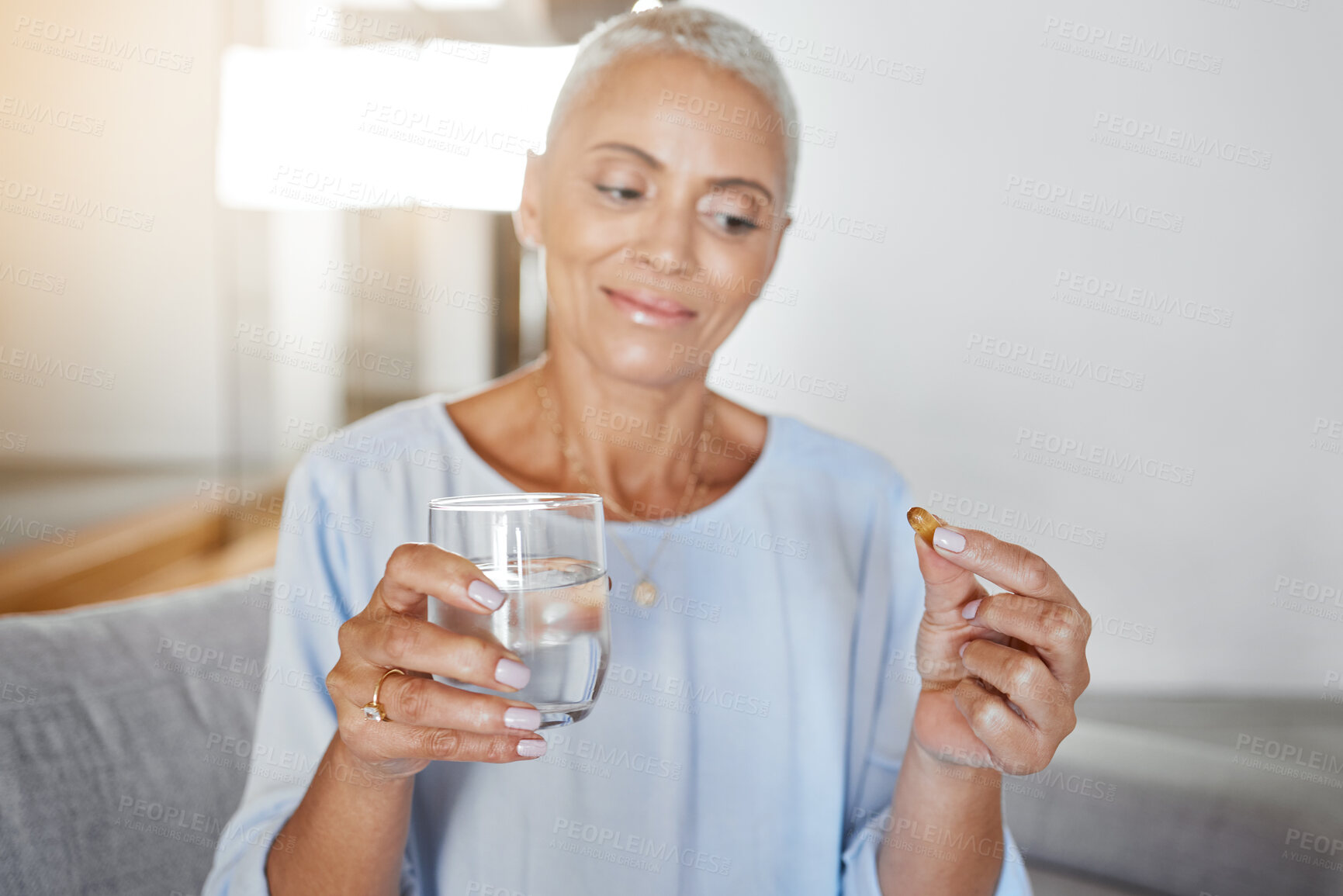 Buy stock photo Senior woman, pregnancy pills and water in home on sofa for ivf healthcare treatment, mother wellness and prenatal care. Elderly woman, drink vitamin medicine and pregnant pharmaceutical support