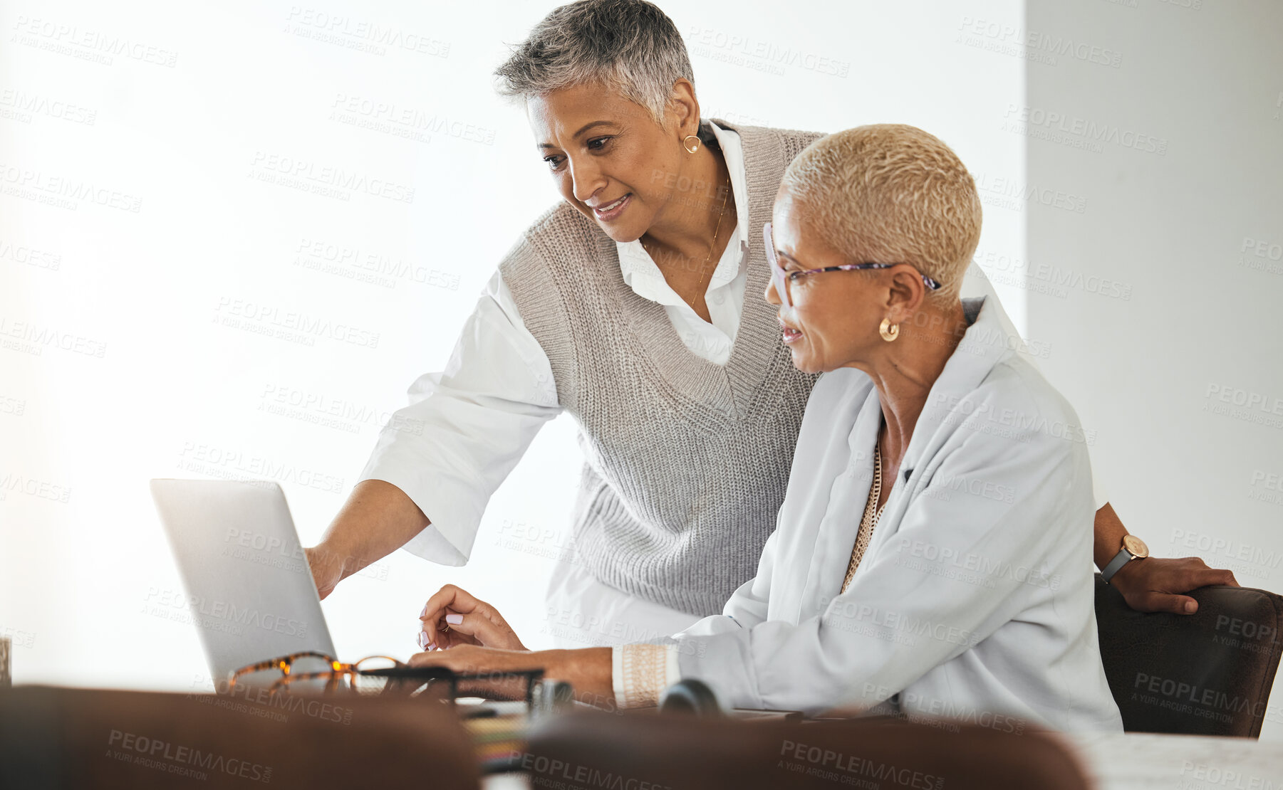 Buy stock photo Laptop, office and senior business women in collaboration planning a corporate project together. Teamwork, professional and elderly manager helping a mature employee with a report in the workplace.