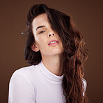 Portrait, hair and beauty with a model woman in studio on a brown background for natural or keratin treatment. Face, hair care and luxury with an attractive young female posing to promote haircare