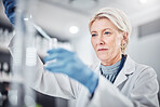 Senior woman, science beaker and pipette in laboratory for medical research. Scientist, innovation and elderly female doctor experimenting, analysis or testing and researching virus cure with dropper