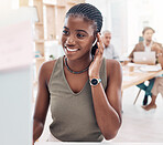 Music, podcast and woman at computer with earphones in office with streaming service while working. Work, smile and happy black woman listening to streaming radio station app online in modern office.