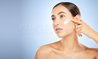 Buy stock photo Woman, face and thinking for beauty cream application, skincare wellness and organic moisturizer product in blue background. Model, luxury dermatology and salon spa facial care or sunscreen in studio