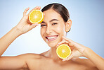 Woman, skincare portrait and lemon for beauty, health and wellness with vitamin c, happy and smile. Model, fruit and happiness for self care, clean radiant glow and skin by blue background in studio