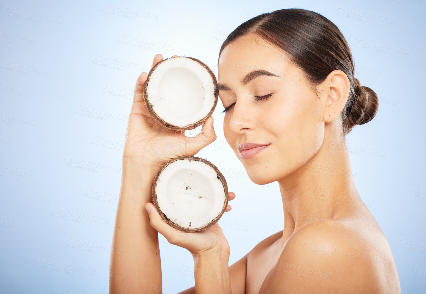 Buy stock photo Skincare, wellness and face of woman with coconut on blue background for dermatology, body care and beauty. Spa, salon and girl with fruit for natural beauty products, cosmetics and facial treatment